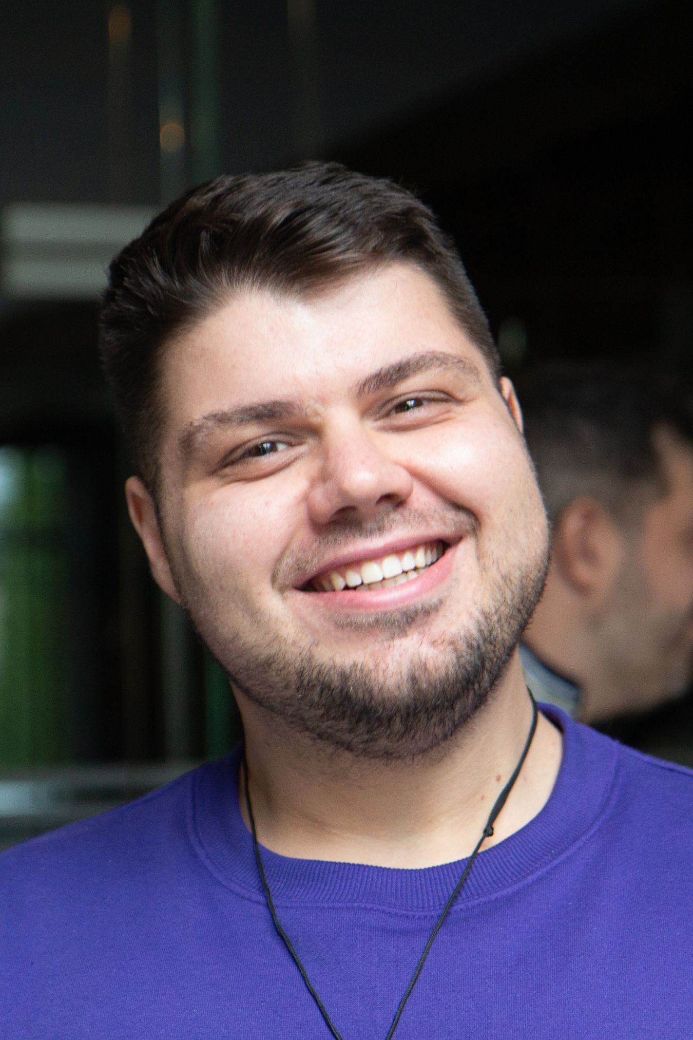 Person holding mobile phone while working on his laptop